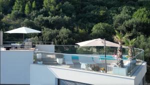 a house with a swimming pool with umbrellas at VILLA ONEUM - Apartment SOL with privat POOL in Omiš