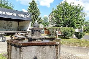 una fuente en un patio frente a un edificio en La Ferrandaise, en Chambon-sur-Lac