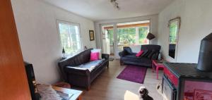 a living room with two couches and a tv at Ferienhaus am Wald in Reichshof 