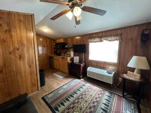 a living room with a ceiling fan and a rug at Waterfall Cottage in Cosby