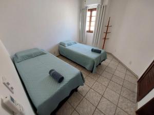 a room with two beds and a window at Casa ao lado da praia in Barra de São Miguel +30 photos