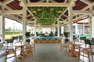 a restaurant with tables and chairs in a building at SBH Gloria Hue in Hue