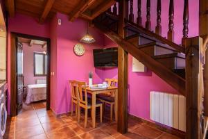 ein Esszimmer mit einem Tisch und einer lila Wand in der Unterkunft Apto Rosa - Casa el gaitero in Susacasa + 18 Fotos