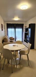 una sala de estar con una mesa, sillas y un sofá en Edifico Orbiplaya, en Torrevieja