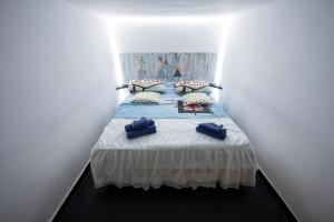 a bedroom with a bed with blue pillows at the Lighthouse accommodation in Taranto