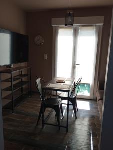 a dining room with a table and chairs and a television at Maison du causse in Magalas