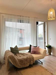 a living room with a couch and a window at Moderni kaksio lähellä keskustaa in Seinäjoki