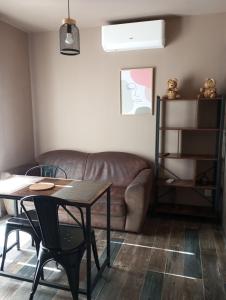 a living room with a couch and a table at Maison du causse in Magalas +3 photos
