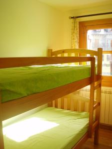 Dos literas en una habitación con ventana. en Apartamento Lamatriz Dequin Edificio Sayo 8, en Benasque