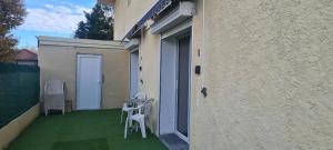 a small balcony with a white chair on the side of a building at Joli T1 bis fonctionnel à Montussan in Montussan