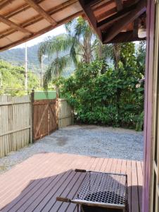 Un patio con una mesa y una valla en Kitnet contêiner climatizada, en Ubatuba