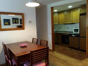 cocina y comedor con mesa de madera en Apartamento Lamatriz Dequin Edificio Sayo 8, en Benasque