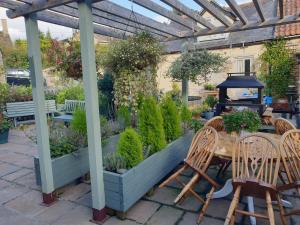 a patio with a table and chairs and plants at The horse and panniers guest house. in North Luffenham