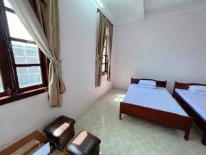 a room with two beds and two chairs in it at Thanh Dat 1 Hotel in Bắc Ninh