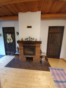 a living room with a brick fireplace and two doors at IT-Hutorok in Turʼya Paseka