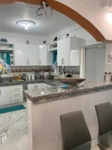 a kitchen with white cabinets and a marble counter top at Modern Country Side Lux Apt in La Ceibita