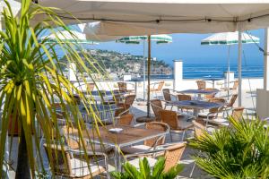 a patio with tables and chairs and a view of the ocean at Hotel Bel Tramonto in Casamicciola Terme
