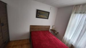 a bedroom with a bed with a red blanket at A&C apartment in Aarhus