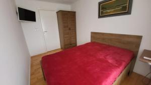 a room with a red bed with a red blanket at A&C apartment in Aarhus