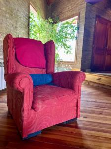 a red couch sitting in a living room at Chalet El Sauce in Neuquén