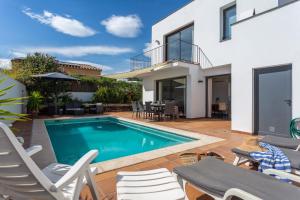 a swimming pool in the backyard of a house at Casa Alexandra in L'Escala