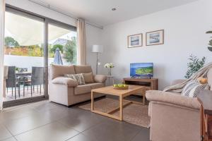 a living room with a couch and a tv and a table at Casa Alexandra in L'Escala