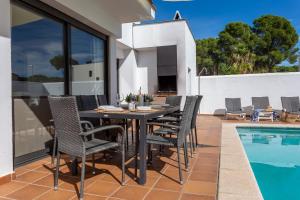 a patio with a table and chairs next to a swimming pool at Casa Alexandra in L'Escala