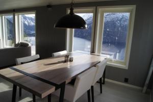 a dining room table with white chairs and a large window at Chalet with amazing fjord view in Lingåsen in Valldal +25 photos