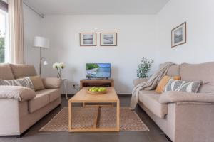 a living room with two couches and a coffee table at Casa Alexandra in L'Escala