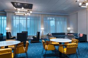 a lobby with tables and chairs and a couch at Courtyard by Marriott Dallas Frisco in Frisco +21 photos