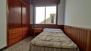 ein kleines Schlafzimmer mit einem Bett und einem Fenster in der Unterkunft Apartamento Mirador de Cee in Cee