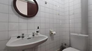 ein Badezimmer mit Waschbecken, Toilette und Spiegel in der Unterkunft Apartamento Mirador de Cee in Cee + 9 Fotos