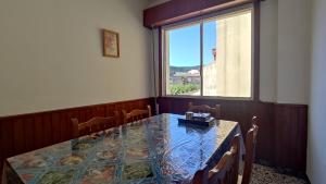 ein Esszimmer mit einem Tisch und einem Fenster in der Unterkunft Apartamento Mirador de Cee in Cee