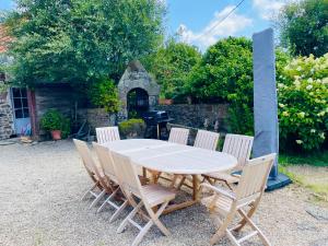 a wooden table with four chairs and a grill at Traou ar Vilin in Pleumeur-Bodou
