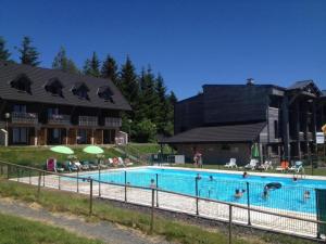 una gran piscina frente a un edificio en SUPER BESSE station LE GITE BESSARD 2 quartier bois de la reine 5 couchages, en Vassivière