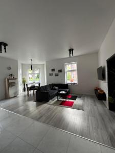 a living room with a black couch and a tv at I'M Apartment SILVER II centrum free parking in Bolesławiec