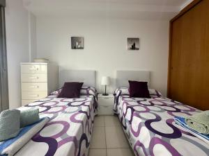 two beds sitting next to each other in a bedroom at Samsara Beach in Port d'Alcudia