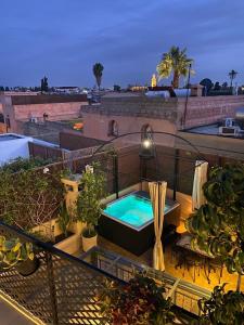 a balcony with a hot tub on top of a building at Riad ART DE VIVRE avec Jacuzzi in Marrakech