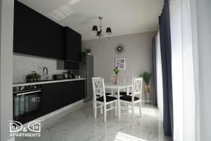 a kitchen with a white table and chairs in it at Pine Tree House 6 in Międzywodzie