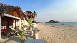 a beach with chairs and buildings and the ocean at CHEZ ALEX in Nosy Be