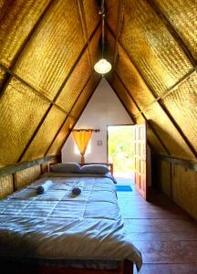a bedroom with a large bed in a pointed ceiling at Phu Aunna in Ko Phayam