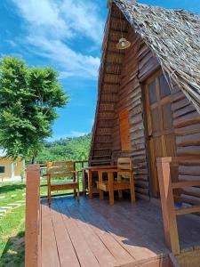 a cabin with a table and benches on a deck at Phu Aunna in Ko Phayam