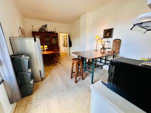 a kitchen with a table and a refrigerator at Maison Mǔso in Dinant