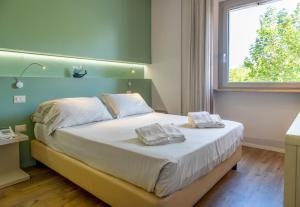 a bedroom with a bed with two towels on it at Hotel De La Ville depandance di Hotel Augustus in Fano