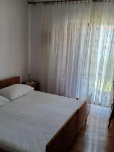 ein Schlafzimmer mit großem Bett und Fenster in der Unterkunft Apartment Marin in Tisno