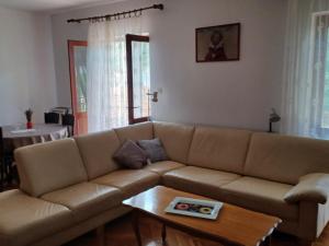 ein Wohnzimmer mit einem braunen Sofa und einem Tisch in der Unterkunft Apartment Marin in Tisno