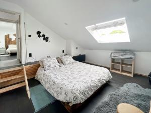 a bedroom with a bed and a skylight at Le Gite des Farfadets in Flangebouche