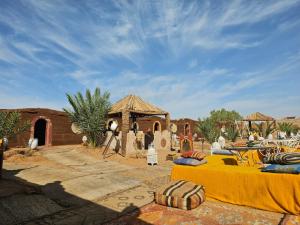 a desert area with a tent and a building at Desert Mhamid Luxury Camp in Mhamid el Rhozlane