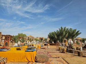 a group of tables and chairs in the desert at Desert Mhamid Luxury Camp in Mhamid el Rhozlane