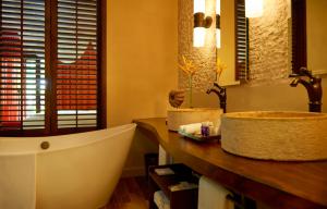 a bathroom with a sink and a bath tub at STORY Seychelles in Beau Vallon
